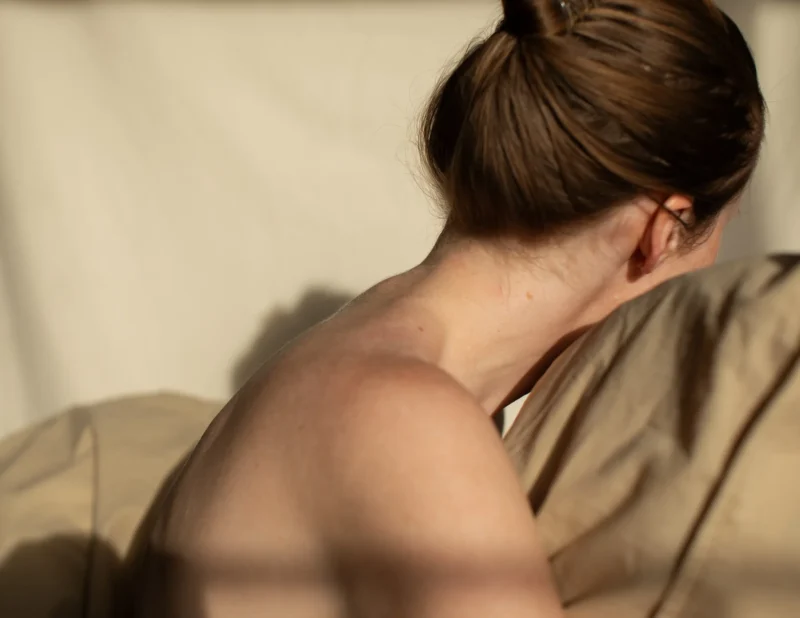 Woman's neck and shoulder in a robe, warm side light